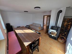 a living room with a table and a wood stove at Apartmány Kutěj in Mutěnice