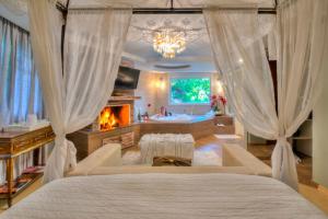 a bedroom with a bed and a fireplace and a tub at La vanguardia by Don Ramon Hotel Boutique & Spa in Canela