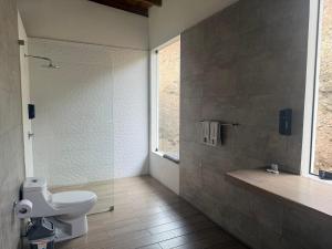 a bathroom with a toilet and a sink and a window at Ranch Pachacamac in Pachacamac +33 photos