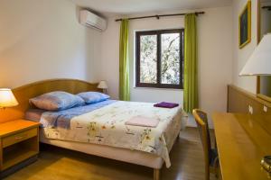 a bedroom with a bed and a window and a table at Robinson Danica 1 in Gornji Dingač