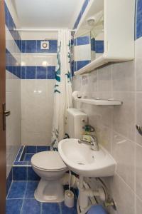 a bathroom with a white toilet and a sink at Robinson Danica 1 in Gornji Dingač +38 photos