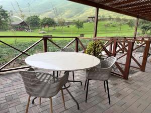 a table and chairs on a patio with a view of a field at Ranch Pachacamac in Pachacamac