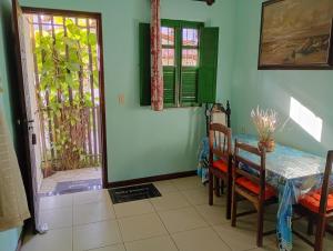 a dining room with a table and chairs and a door at Casa na cidade ITAPARICA Bahia House in ITAPARICA town in Itaparica