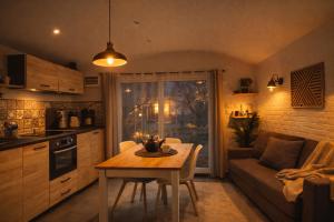 a kitchen with a table and a couch in a room at Cottage cosy avec spa privatif - escapade romantique Val de Loire in Chouzy-sur-Cisse