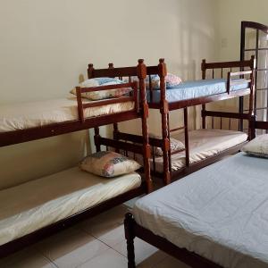a room with three bunk beds and a bed at Pousada Menino do Rio in Ubatuba