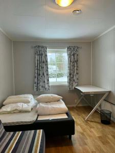 two beds in a room with a window and a desk at Trysil Central Villa in Trysil