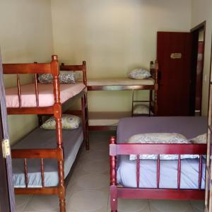 a room with three bunk beds in a room at Pousada Menino do Rio in Ubatuba