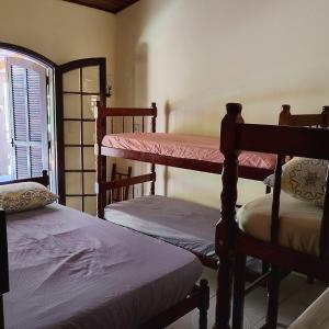 a room with three bunk beds and a window at Pousada Menino do Rio in Ubatuba