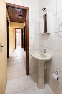 a bathroom with a sink and a mirror at Pousada Menino do Rio in Ubatuba