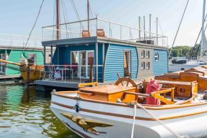 a small boat is docked at a dock at Hausboot Sunshine Heiligenhafen in Viehhof
