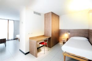 a bedroom with a bed and a desk and a deskablish at Lago & Monte Varese Apartments near Hospital and University in Varese