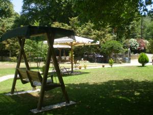 a swing set in a park with an umbrella at Dodis Village in Platanias