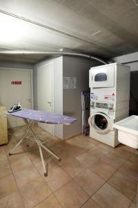 a laundry room with a table and a washing machine at Lago & Monte Varese Apartments near Hospital and University in Varese