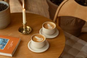 two cups of coffee on a table with a candle at MarinaPark Beach Resort Soal | Beachfront villas in Workum