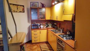 une petite cuisine avec des armoires jaunes et une cuisinière dans l'établissement La Ciammarica, à Sulmona