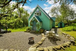 ein Gewächshaus mit einem Tisch und Stühlen davor in der Unterkunft The Tabernacle, Design-led Converted Chapel with Hot Tub, Highland Perthshire in Aberfeldy