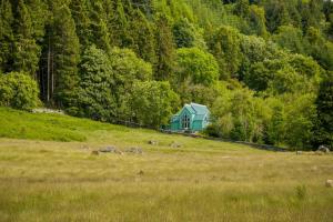 ein Gewächshaus auf einem Hügel in einem Feld in der Unterkunft The Tabernacle, Design-led Converted Chapel with Hot Tub, Highland Perthshire in Aberfeldy