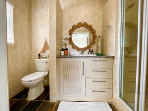 a bathroom with a toilet and a mirror at Pebble Beach Seafront Condo in Swakopmund +36 photos