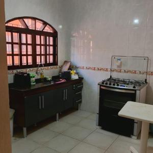 a kitchen with a stove and a sink at Pousada Menino do Rio in Ubatuba +5 photos