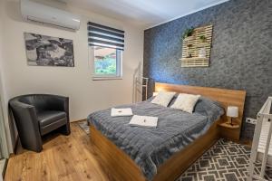 a bedroom with a bed and a chair at Diófaliget Guesthouse in Pogány +78 photos