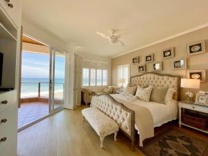 a bedroom with a bed and a view of the ocean at Pebble Beach Seafront Condo in Swakopmund