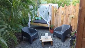 a swing in a garden with two chairs and a table at Cabane Autentikaz in Saint-François