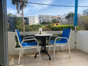 a table and two chairs on a balcony at Rethymno Blue Residence in Rethymno