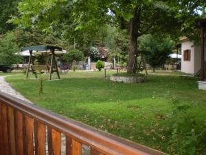 a park with a tree and a playground at Dodis Village in Platanias