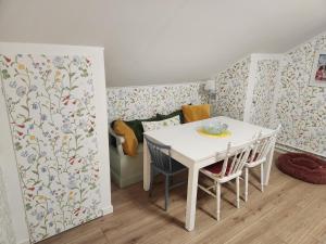 a dining room with a white table and chairs at Sommarlägenhet i Vadstena in Vadstena