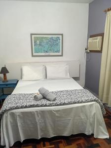 a bedroom with a bed with a hat on it at Roma Hotel in Porto Alegre