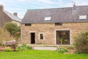 a brick house with a garden in front of it at La longère familiale et authentique in Melgven