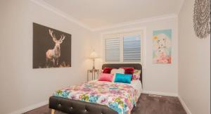 a bedroom with a bed with a deer picture on the wall at Cozy Cottage with Full Kitchen, Backyard & Patio in Tamworth