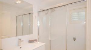 a white bathroom with a shower and a sink at Cozy Cottage with Full Kitchen, Backyard & Patio in Tamworth +18 photos