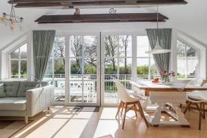 a living room with a table and chairs and a couch at Ferienhof Radlandsichten in Malente