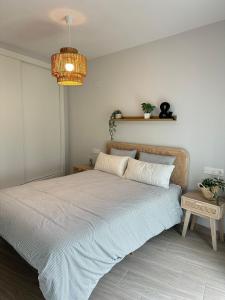 a bedroom with a bed and a chandelier at ABA Malaguita in Conil de la Frontera