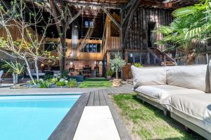a living room with a couch next to a pool at LOFT d'exception Hypercentre avec Piscine in Brive-la-Gaillarde