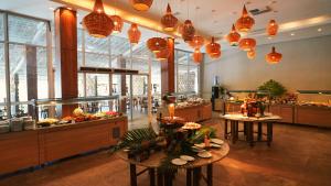 a large kitchen with two tables and many windows at Pratagy Beach All Inclusive Resort in Maceió