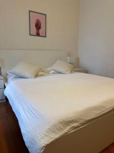 a white bed with two pillows in a bedroom at Zimmer In Luzern in Arni Alp