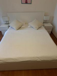 a white bed with two pillows on top of it at Zimmer In Luzern in Arni Alp