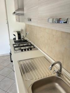 a kitchen with a sink and a stove at Santu Marcu apartment in Decimomannu