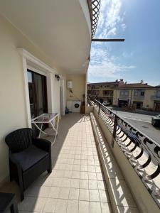 a balcony with a chair and a view of a street at Santu Marcu apartment in Decimomannu
