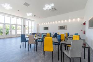 a dining room with tables and colorful chairs at Max Motel - Art Gallery Room in Druento