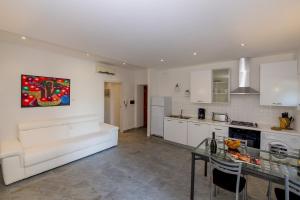 a living room with a white couch and a kitchen at Il Borgo Monolocali in Bellagio +4 photos