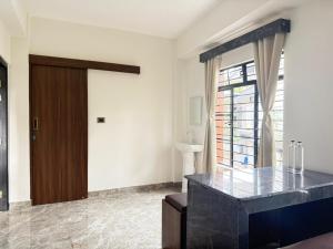 a living room with a wooden door and a window at The Notting Hills Inn in Shillong +30 photos