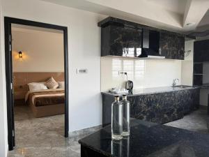 a room with a bed and a kitchen with a mirror at The Notting Hills Inn in Shillong