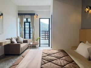a bedroom with a bed and a living room at The Notting Hills Inn in Shillong