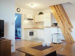 a kitchen with white cabinets and a wooden table at Stems-W4 in Prerow +7 photos