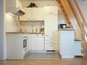 a white kitchen with white cabinets and appliances at Stems-W4 in Prerow