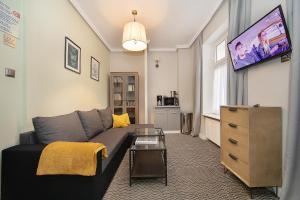 a living room with a couch and a tv at CIENISTA 7 APARTMENTS in Lądek-Zdrój