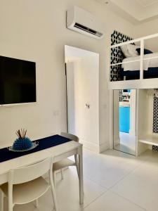 a white living room with a table and a tv at MARILISE - La maison blue private garden & terrace in Meta